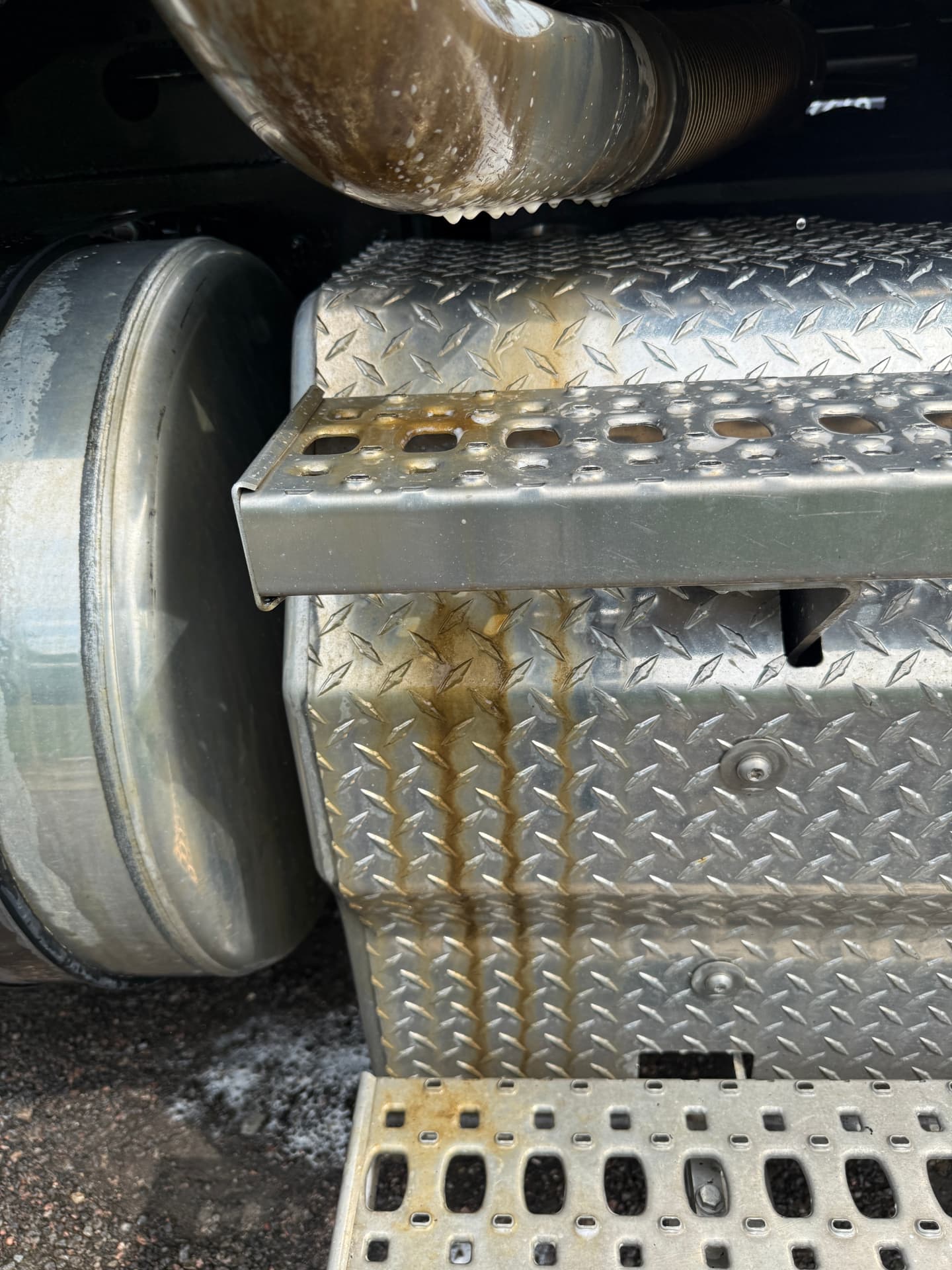 Truck aluminum fuel tank and steps stained with road film and exhaust residue before washing