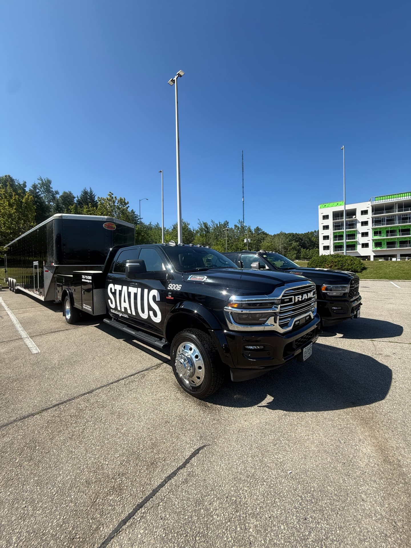 Freshly detailed black RAM work truck with trailer after a Refined Mobile Wash cleaning